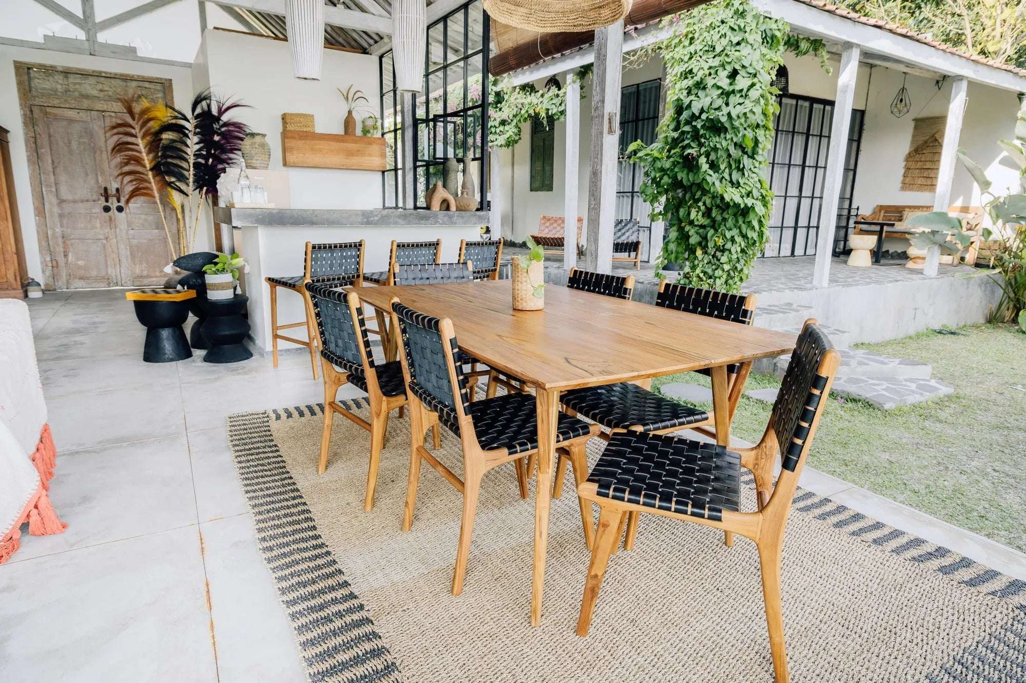 Handmade teak dining set with woven black chairs in a modern outdoor setting, Kayu Living