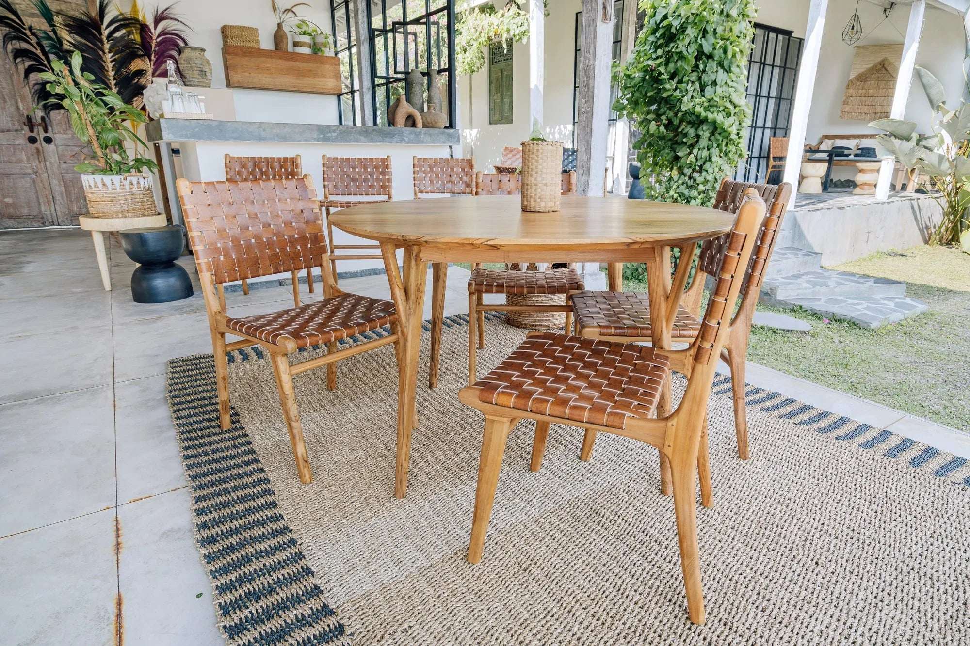 Handmade wooden dining set with woven chairs on natural fiber rug, Kayu Living outdoor decor