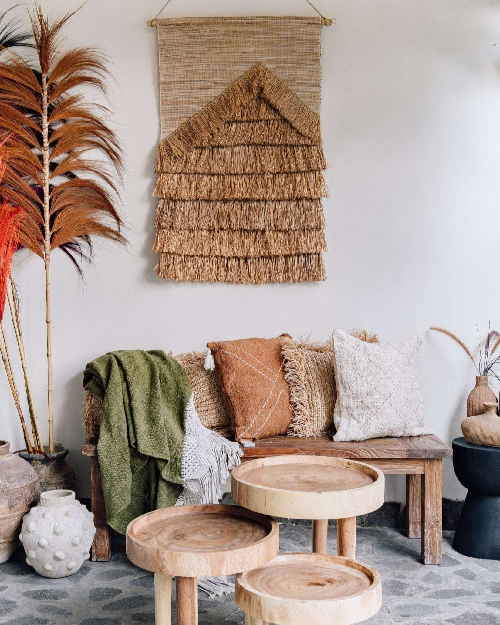 Living room with wooden furniture, decorative pillows, and a woven wall hanging.