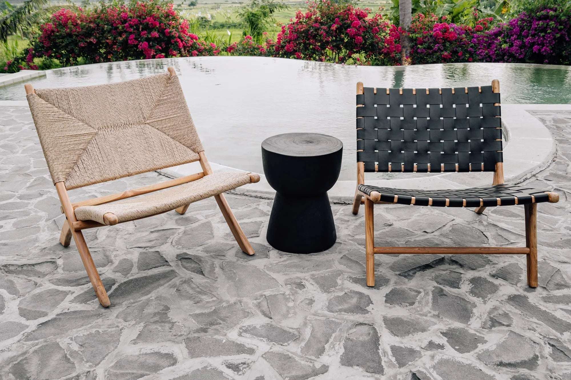 Handmade woven lounge chairs and black side table by a pool, Kayu Living outdoor furniture