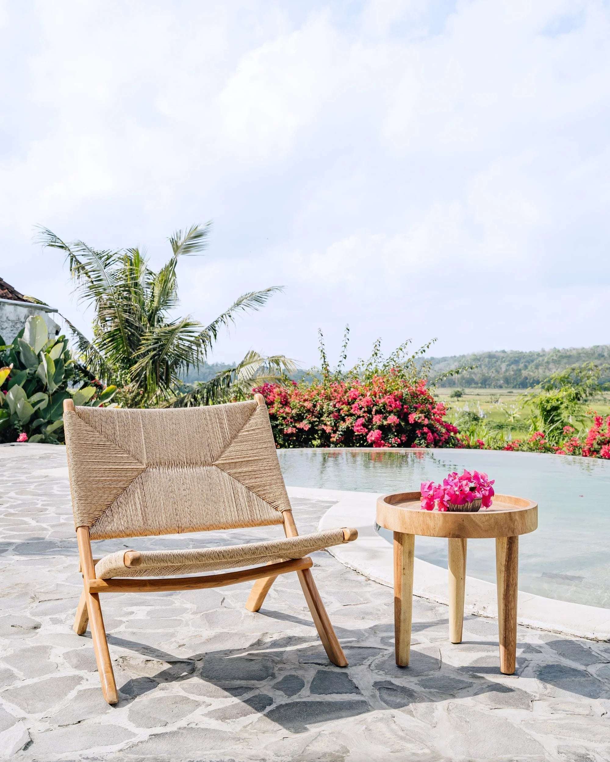 Handcrafted woven lounge chair and wooden side table by pool, Kayu Living outdoor furniture