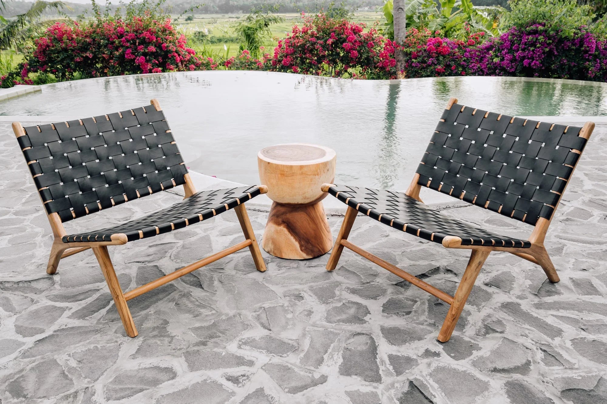 Handmade woven lounge chairs and wooden side table by a pool, Kayu Living outdoor furniture