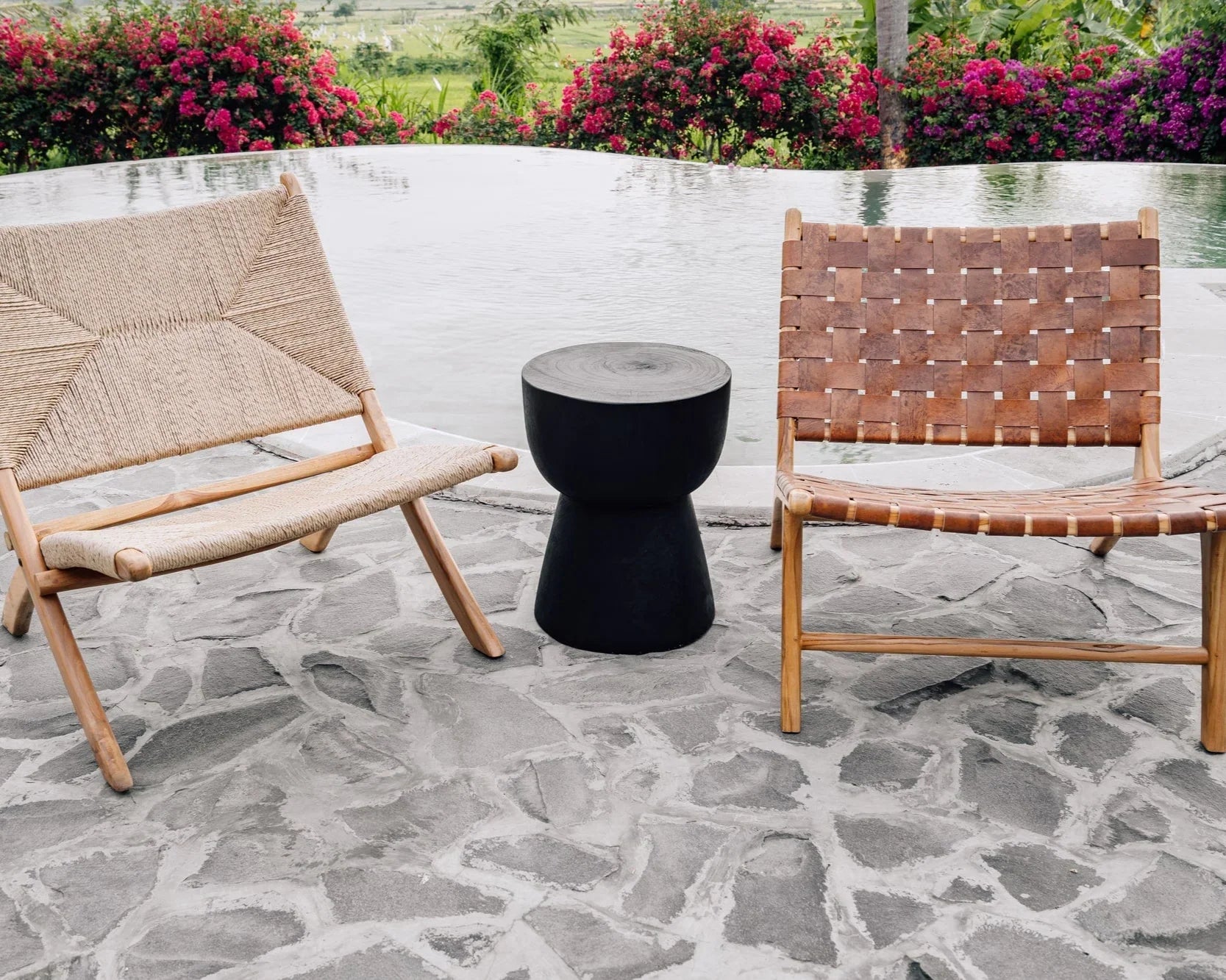 Handmade woven and leather lounge chairs with black side table by pool, Kayu Living outdoor furniture