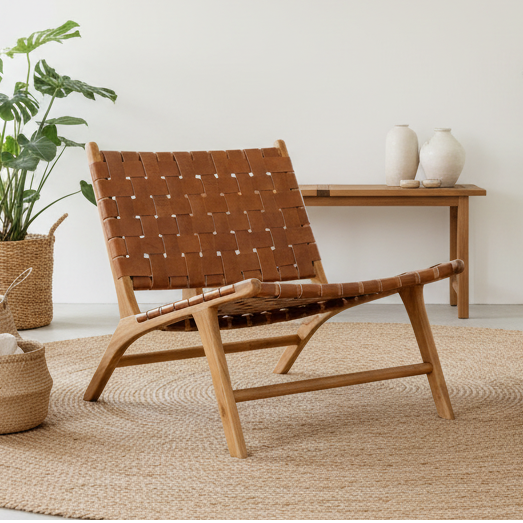 Brown woven chair in a room with plants and a small table.