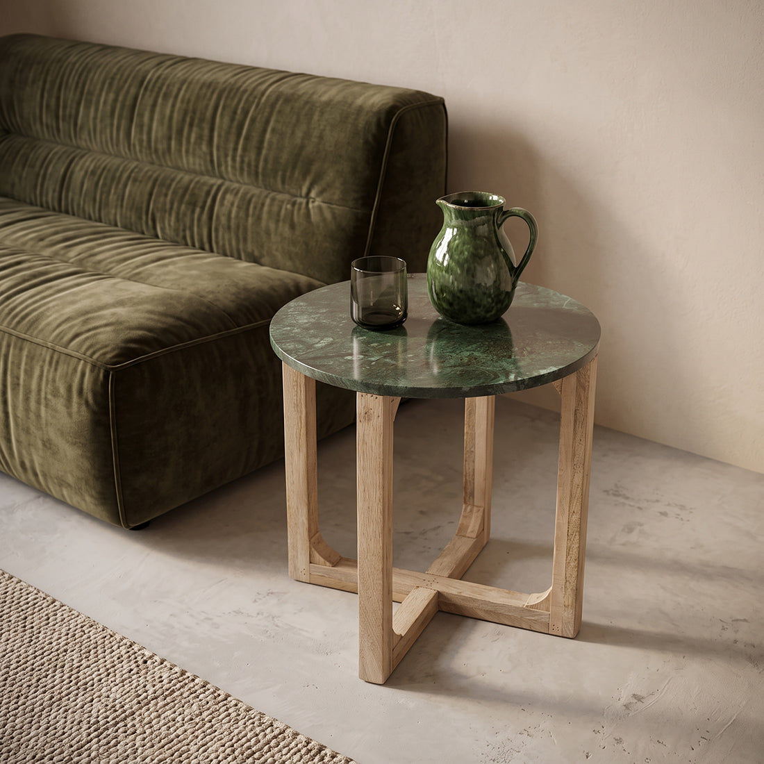 Green marble side table by Raw Materials with a sleek round top and minimalist design on a neutral background.