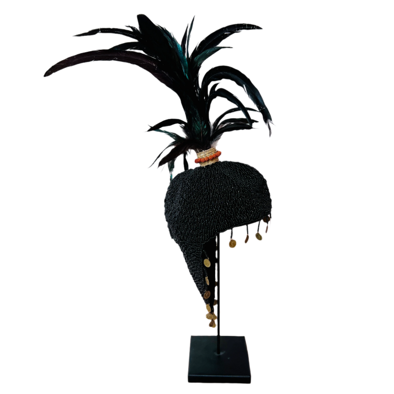 Black feathered headdress on a stand with a white background