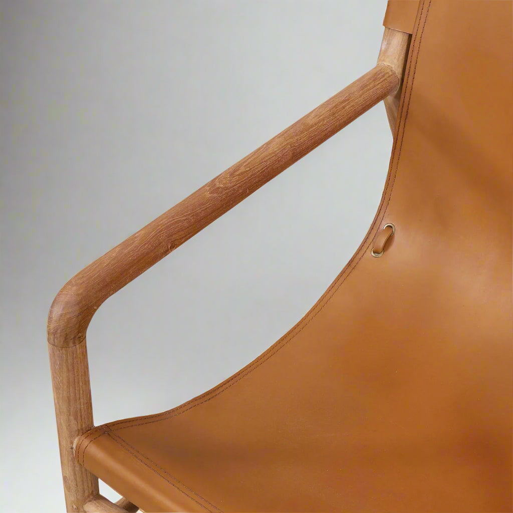 Brown leather chair with wooden armrests on a neutral background