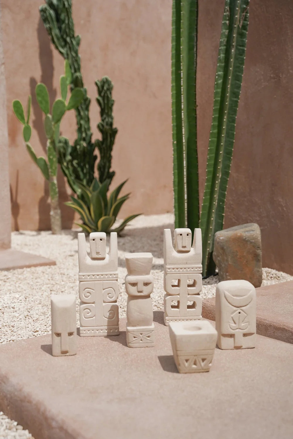 Kayu Living handcrafted Balinese natural stone guardian figurines with carved tribal patterns in a desert garden
