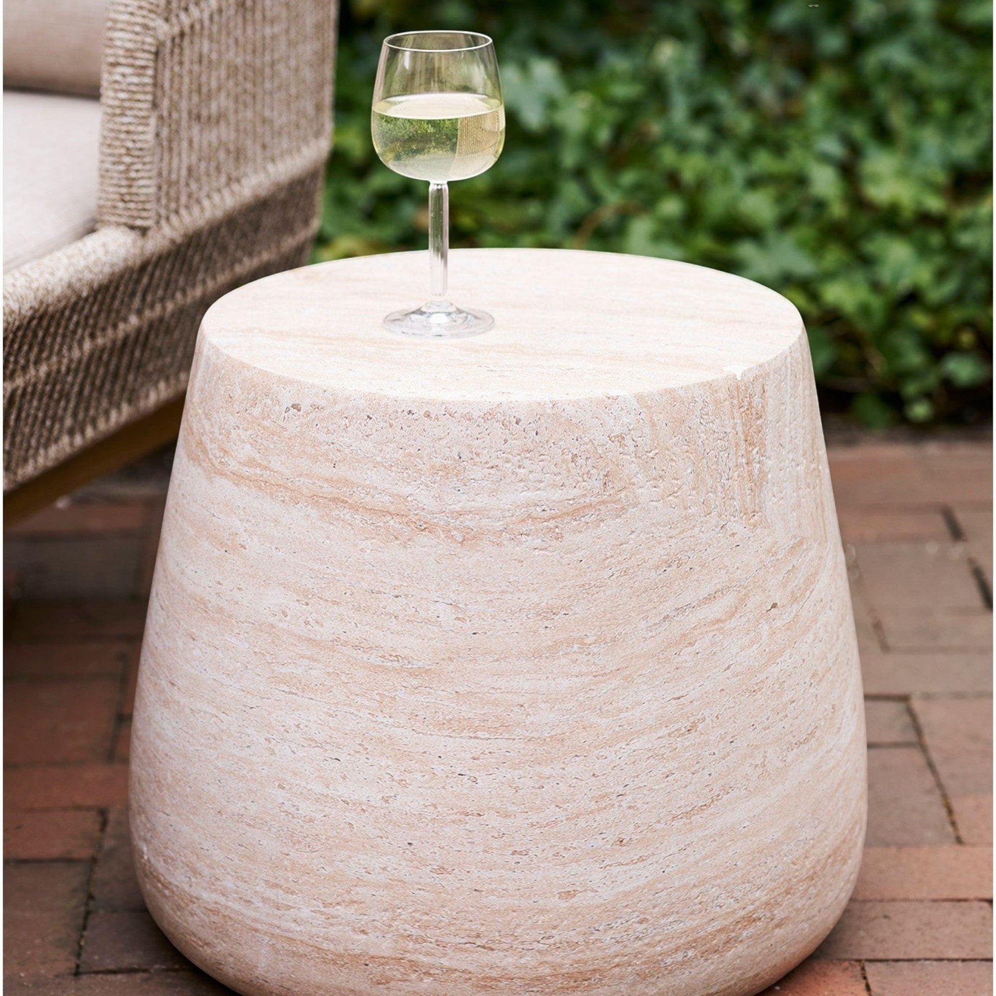 Kayu Living Bonn side table in natural fiberclay with a stone-like finish, featuring a wine glass on top.