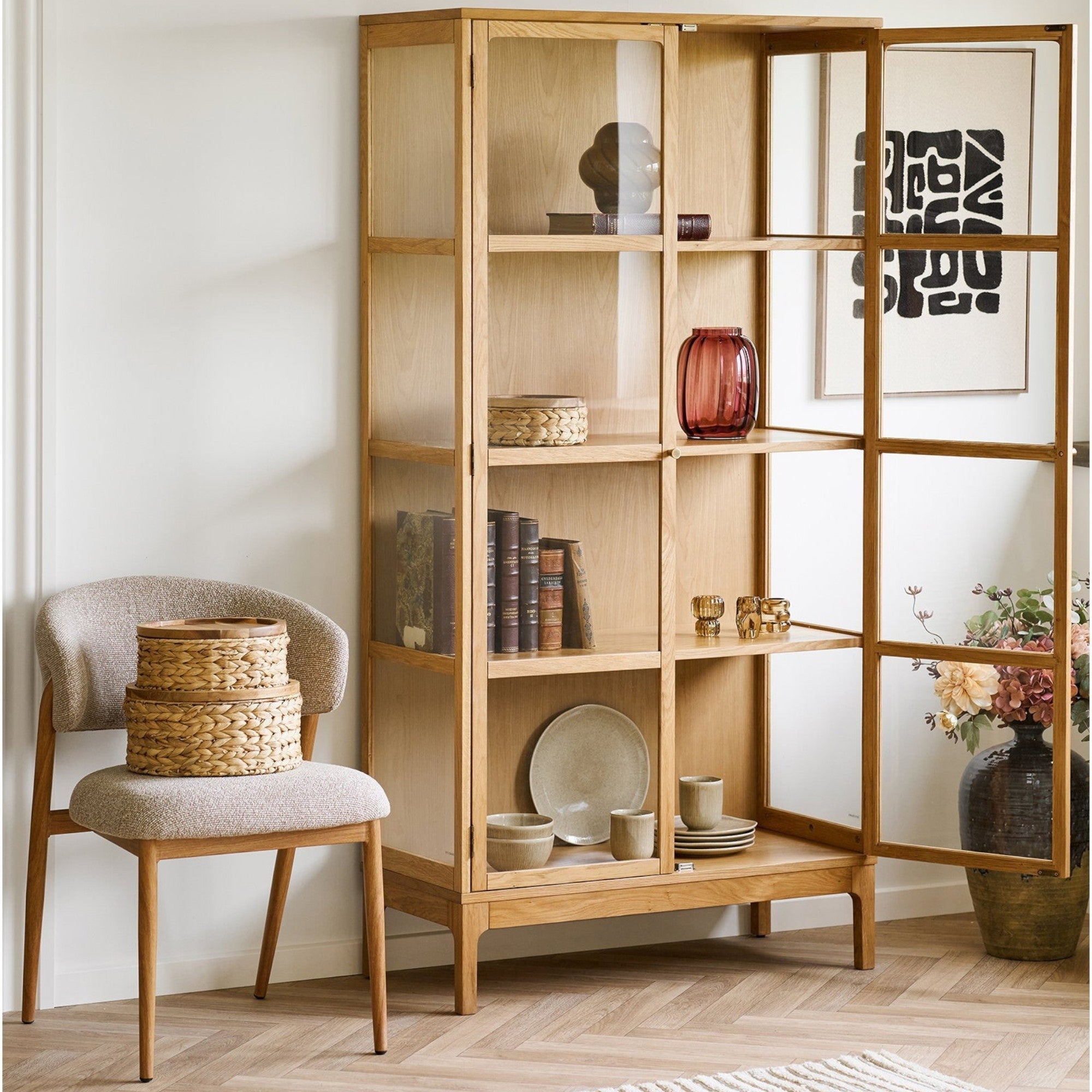 Kayu Living Botofte natural water hyacinth baskets with wooden lids, set of three stacked on a textured accent chair.