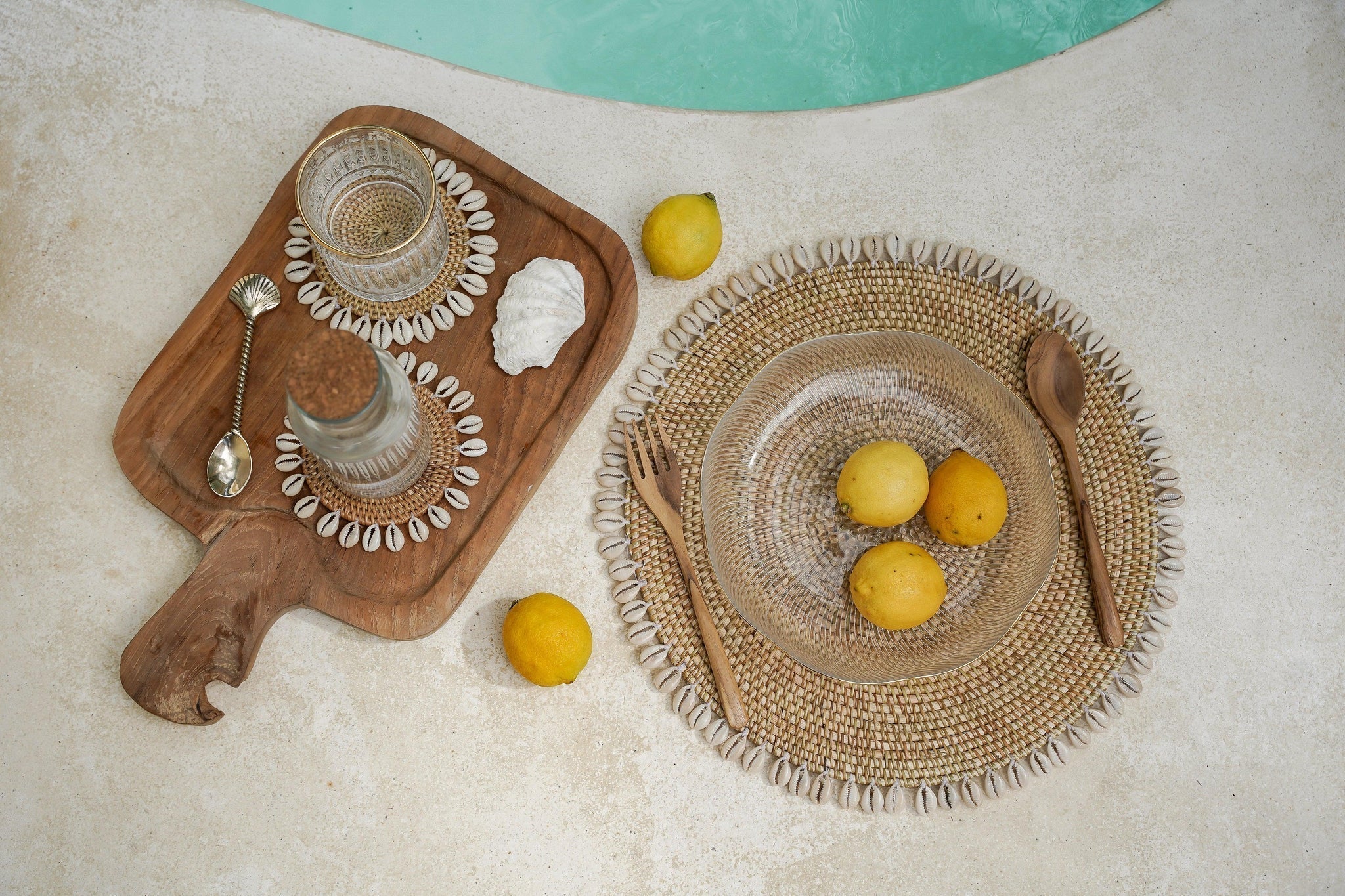 Kayu Living handcrafted brass palm tree spoon with gold finish on a wooden serving board with shell decor