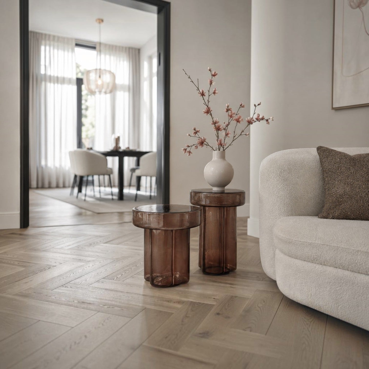 Kayu Living Brix Lio side tables in smoked brown glass with fluted cylindrical bases next to a cream sofa