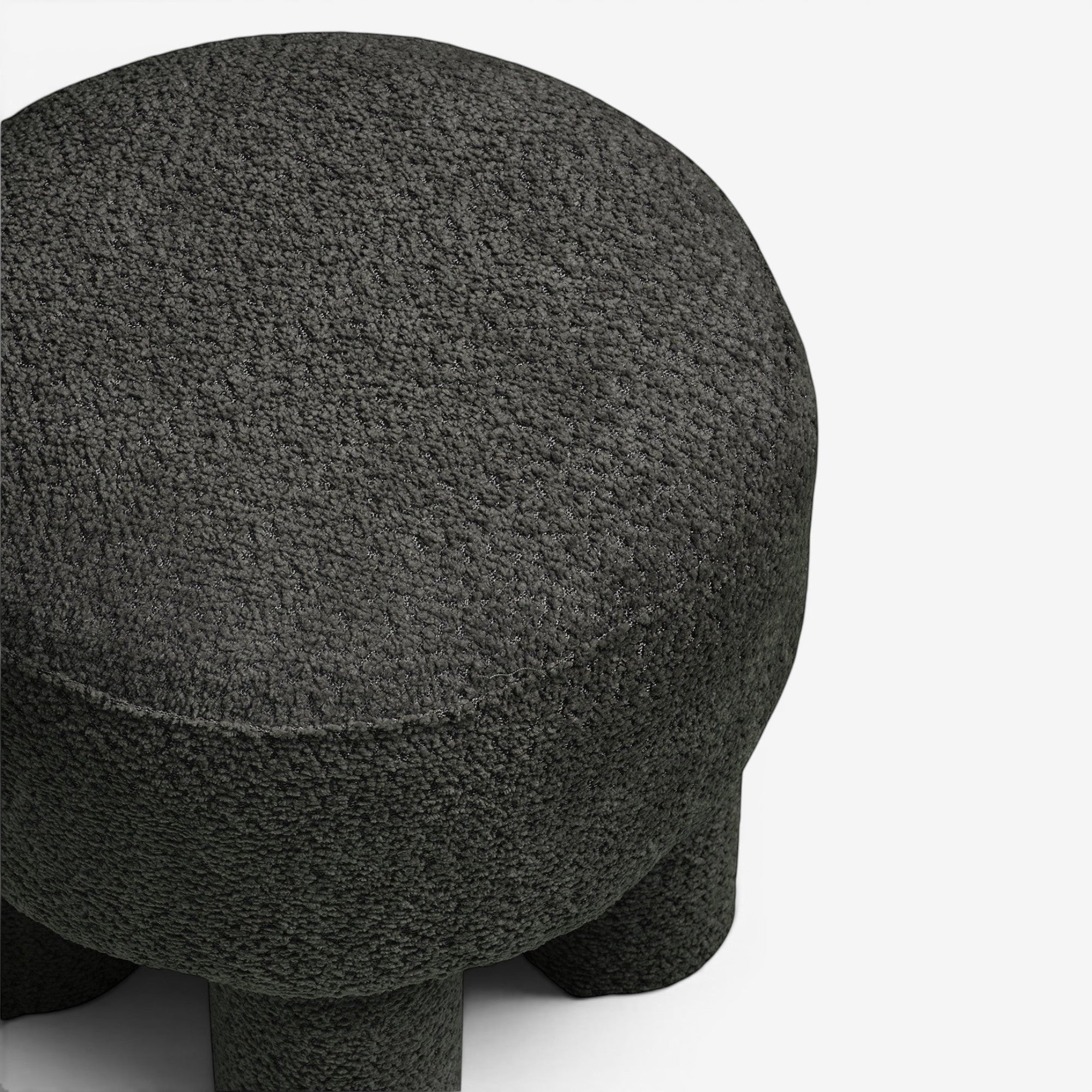 Kayu Living charcoal round pouf upholstered in textured polyester fabric, perfect as a footrest or accent seat.