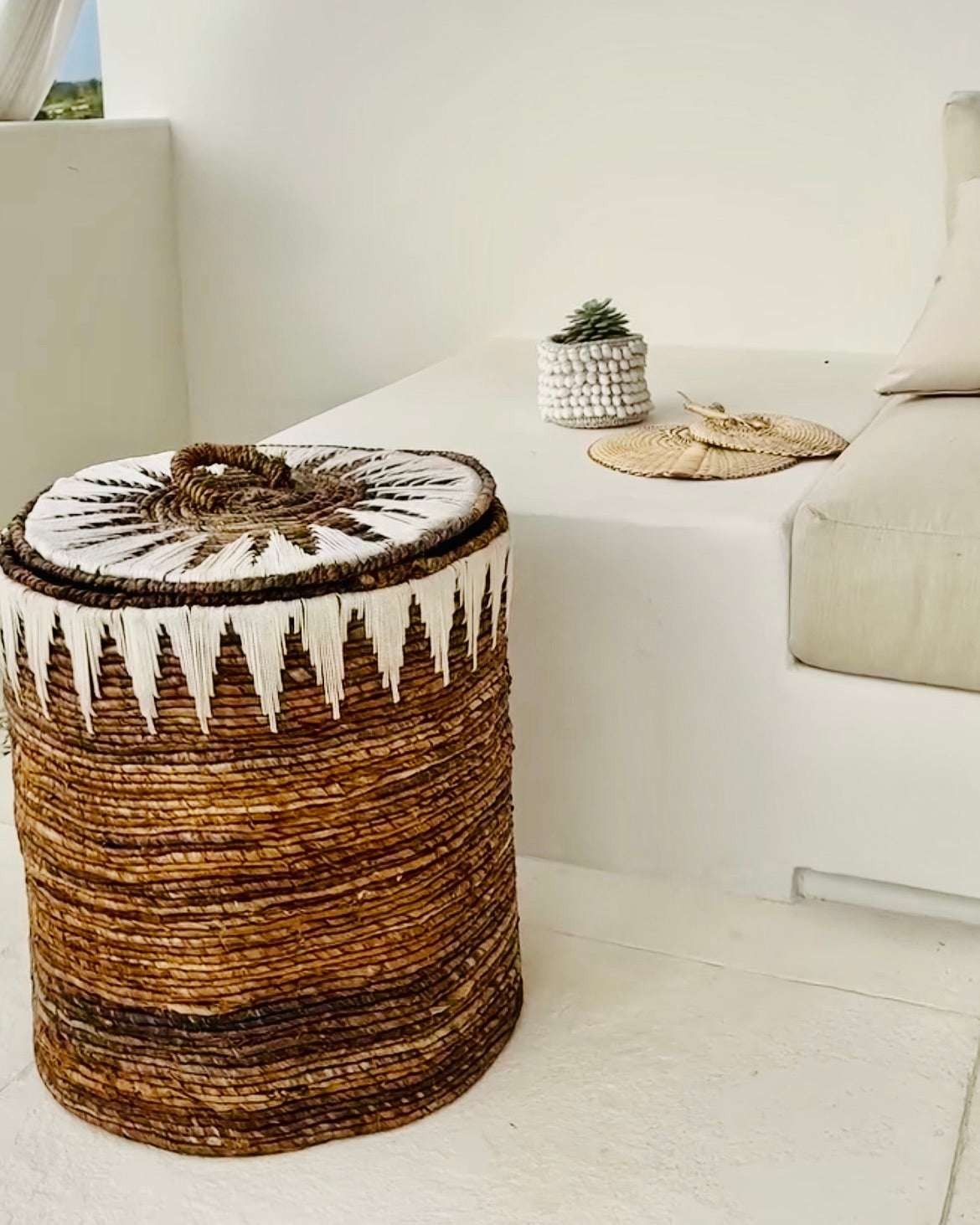Kayu Living banana cord storage basket with lid, featuring white embroidery and a woven handle. Natural brown.