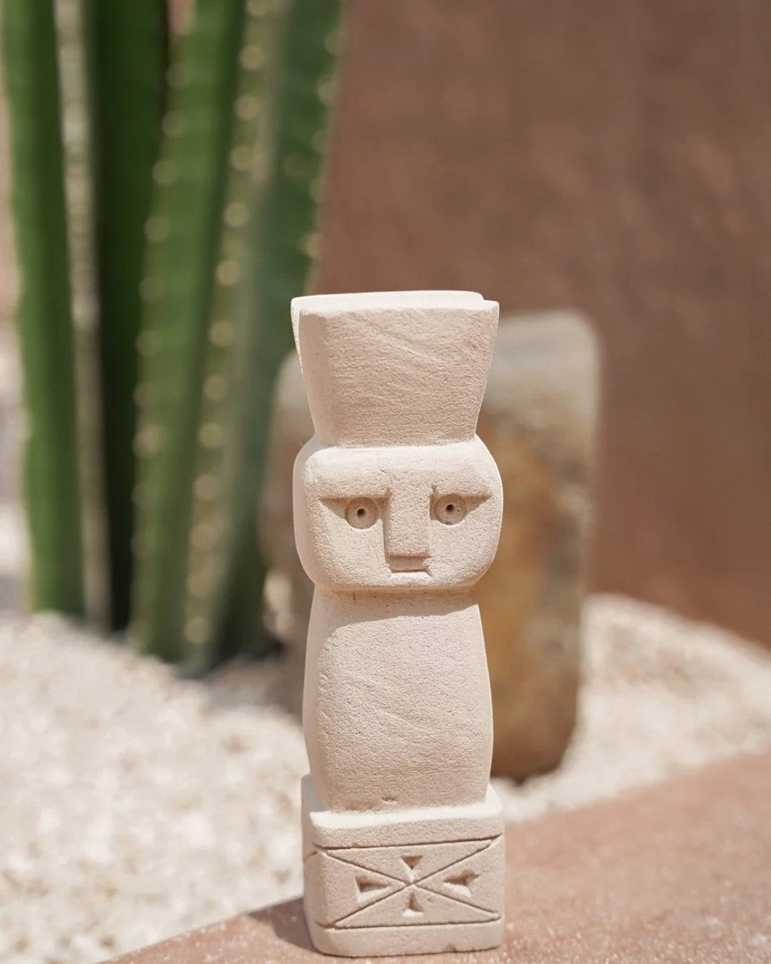 Kayu Living handmade Balinese stone guardian figurine with a natural finish and carved geometric base details.