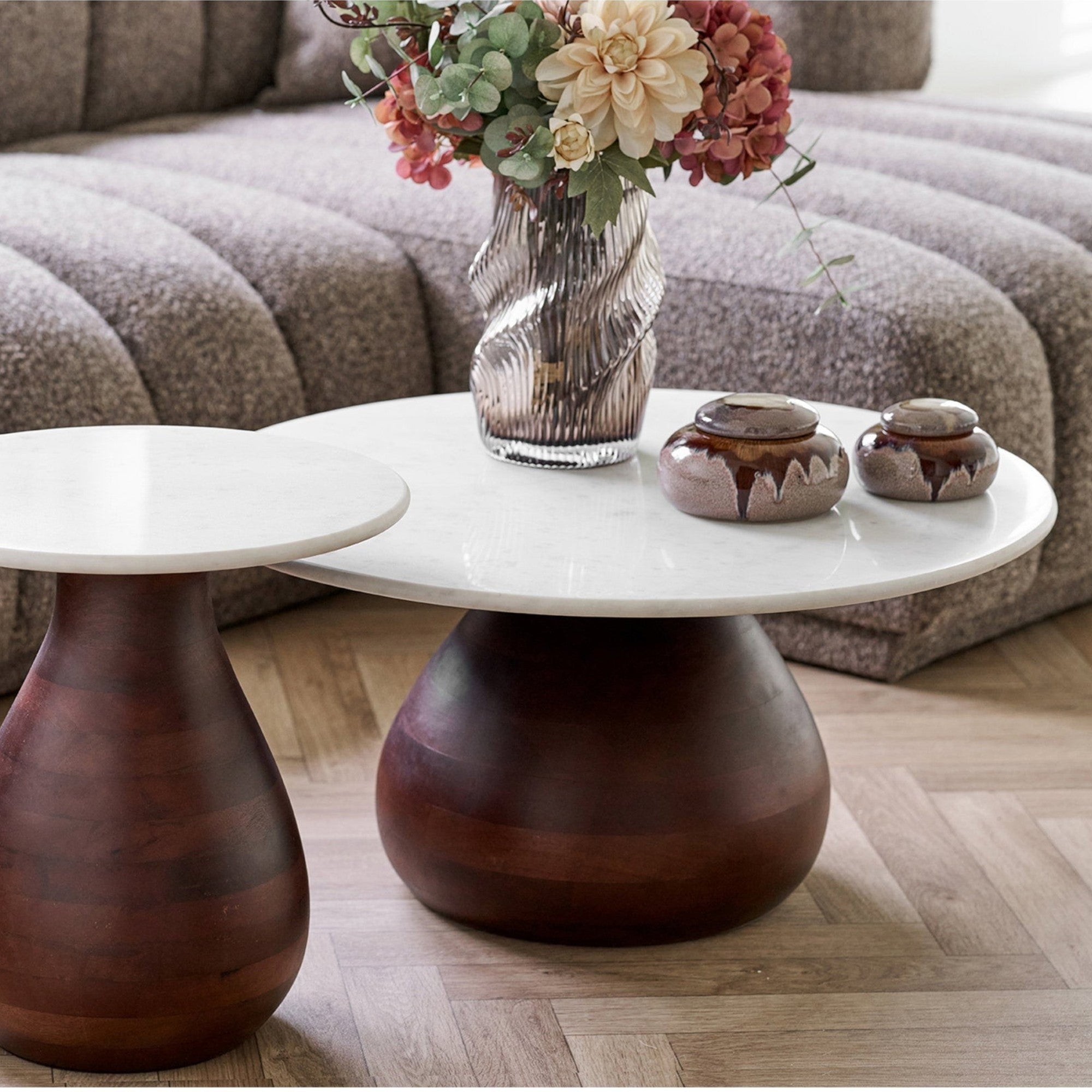 Kayu Living Heide round coffee table with dark brown mango wood base and white marble top in a modern living room.