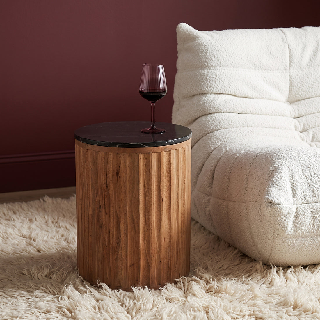 Kayu Living Langkawi side table with a round black marble top and a cylindrical fluted mango wood base.