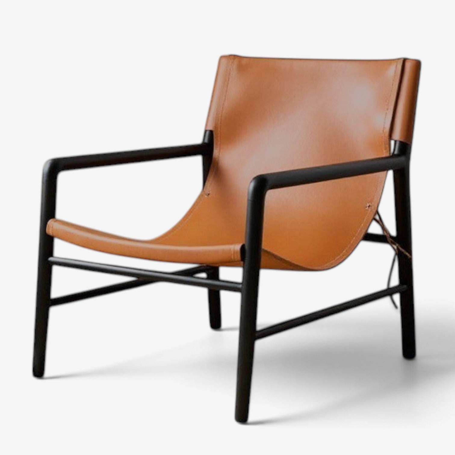 Kayu Living Marita lounge chair with a dark brown teak frame and cognac leather seat in a modern minimalist style.
