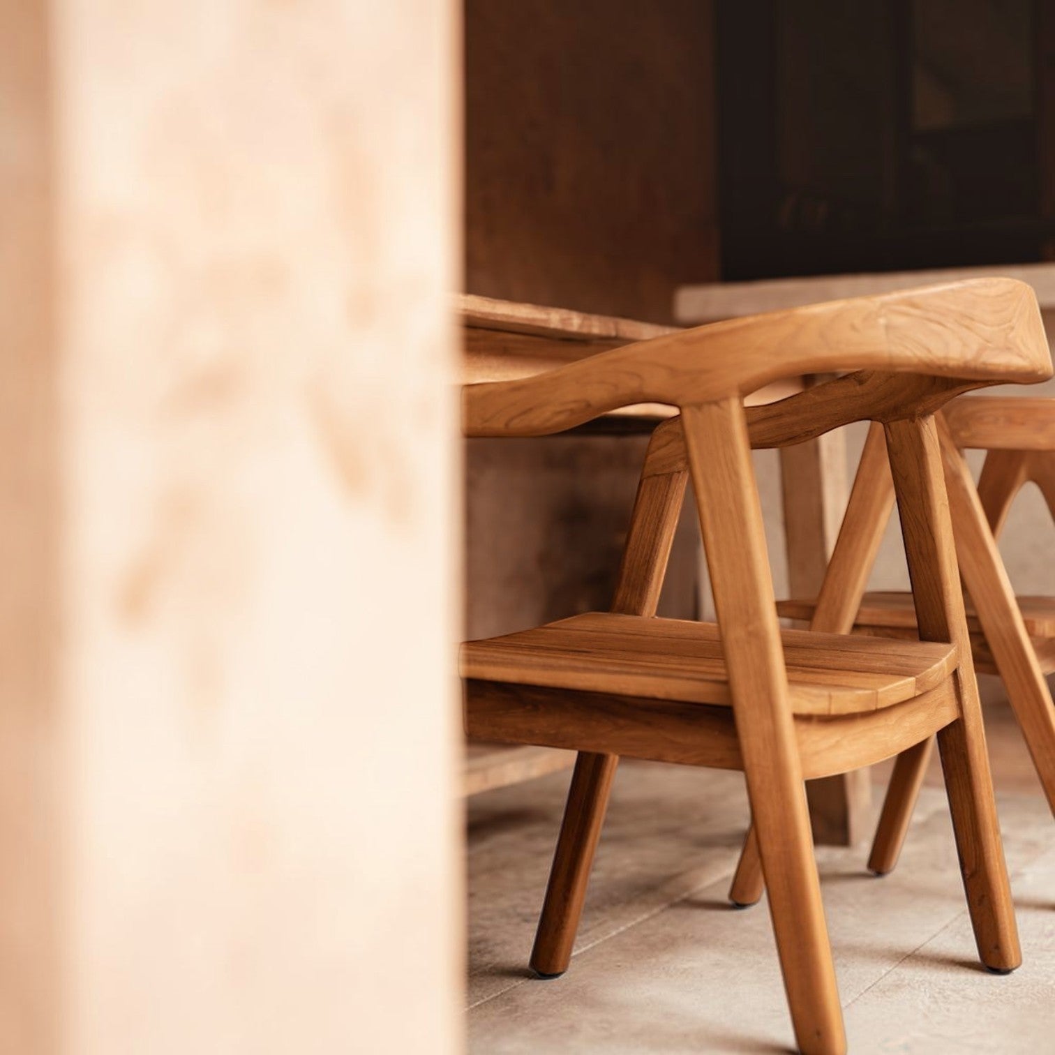 Kayu Living Nihi Oka dining chair made of natural Indonesian teak with sculpted curved back and clean lines.
