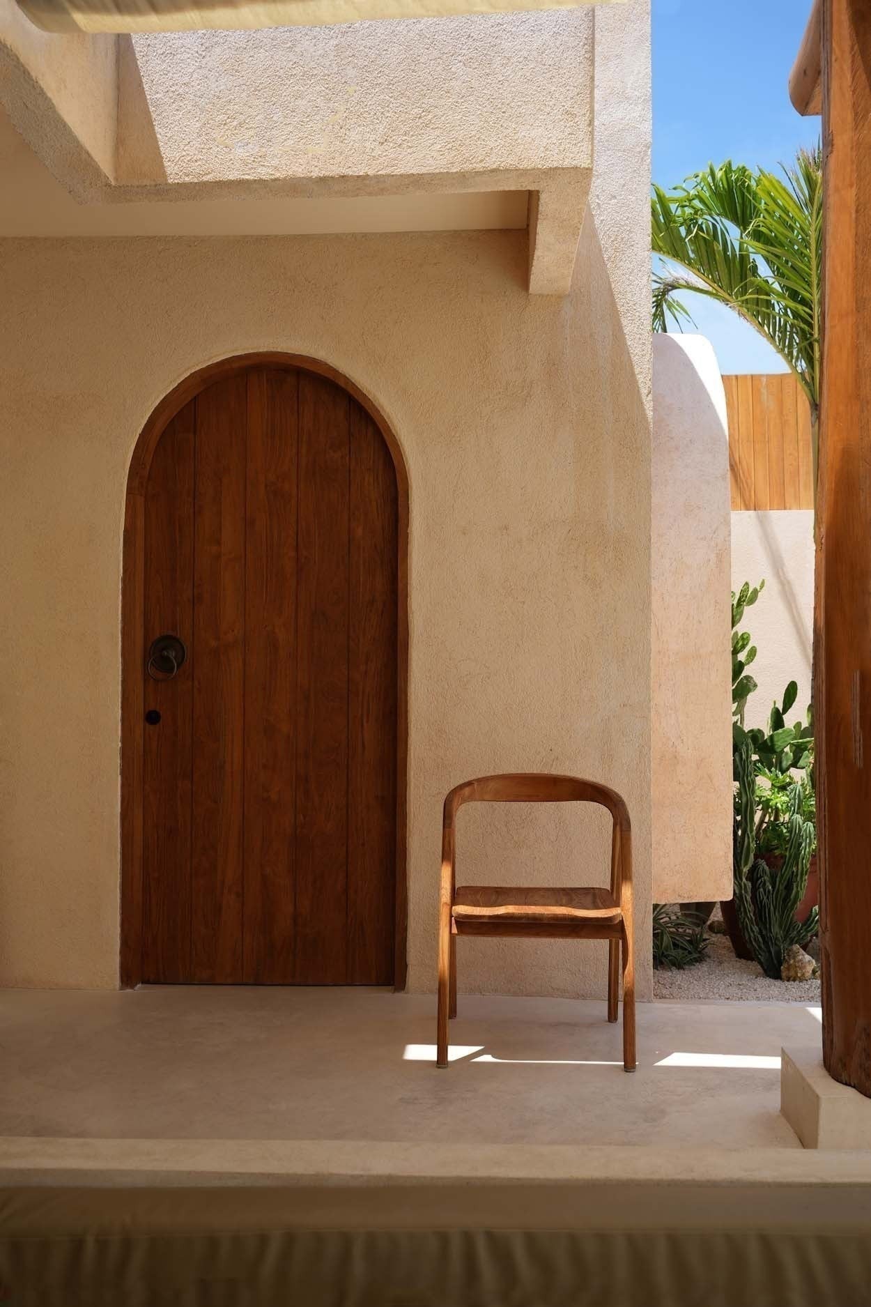 Kayu Living Nihi Oka dining chair in natural teak with curved back and clean lines, perfect for indoor or outdoor use.