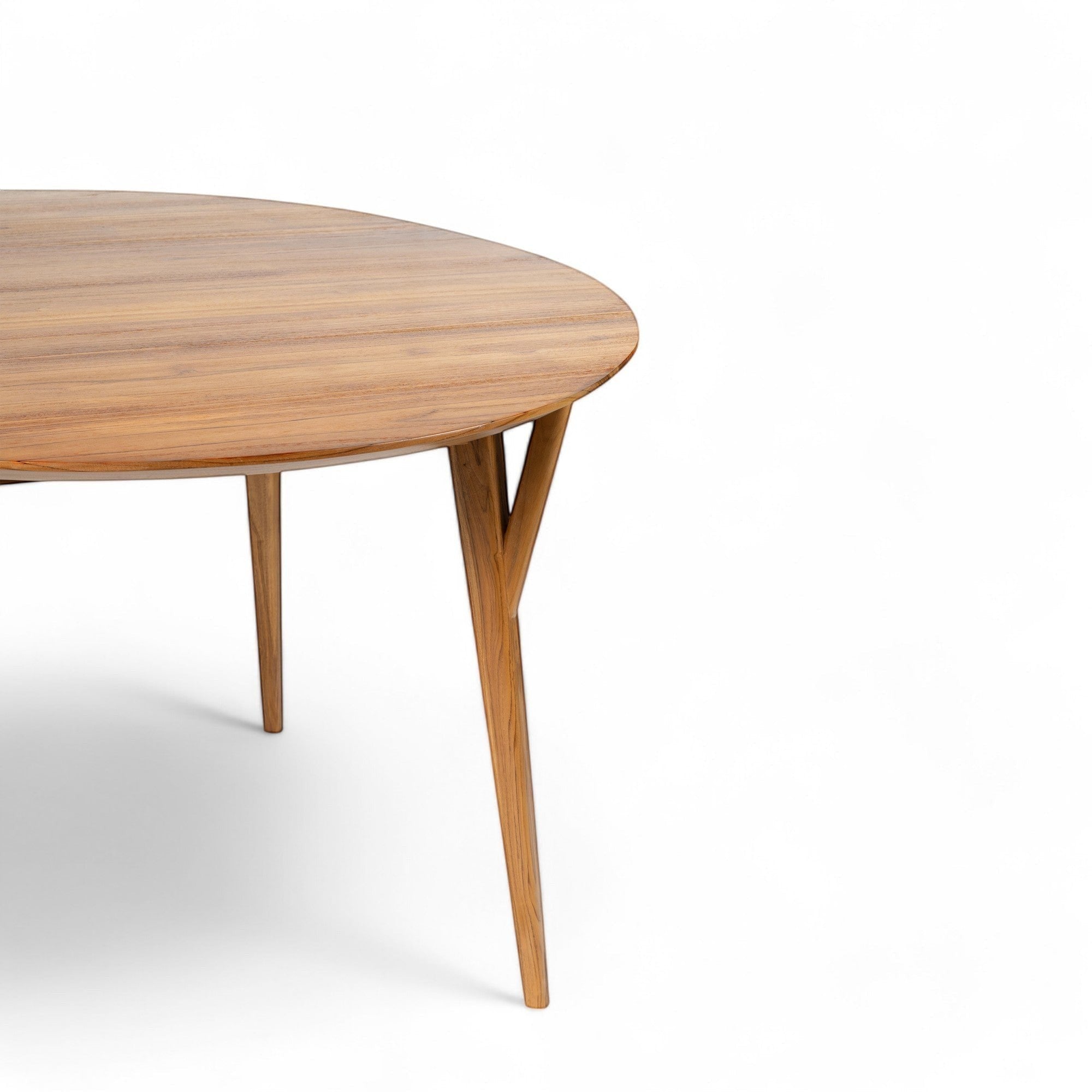 Kayu Living Pantai round teak dining table, 120 cm, with natural wood grain and tapered legs.