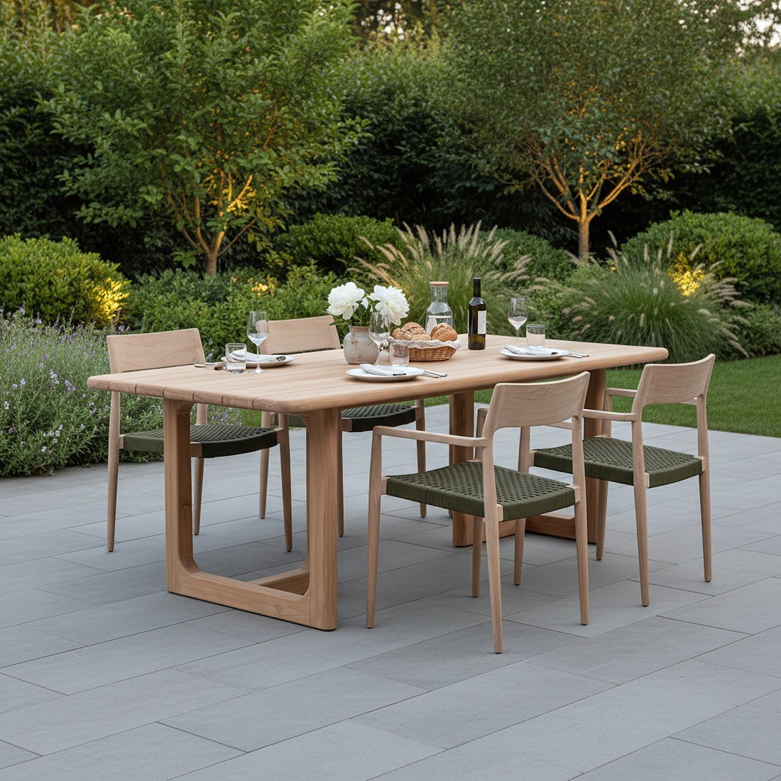 Kayu Living Primavera 200cm recycled teak garden table with rounded edges and U-shaped legs on a stone patio.