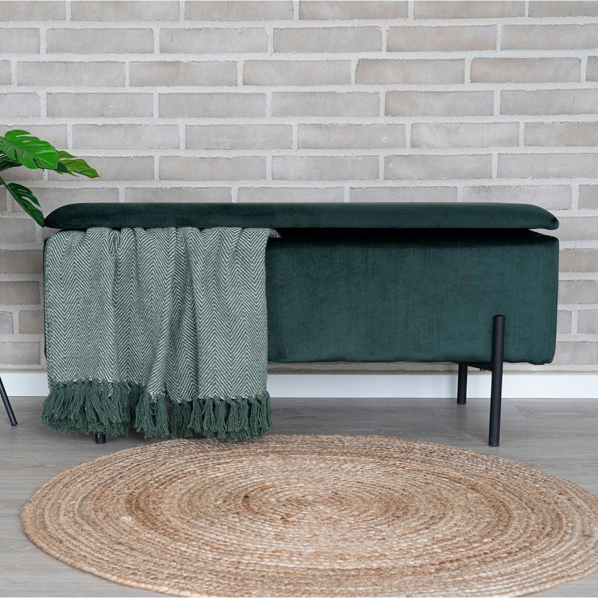 Kayu Living round braided natural jute rug on a light wooden floor in a rustic living room setting