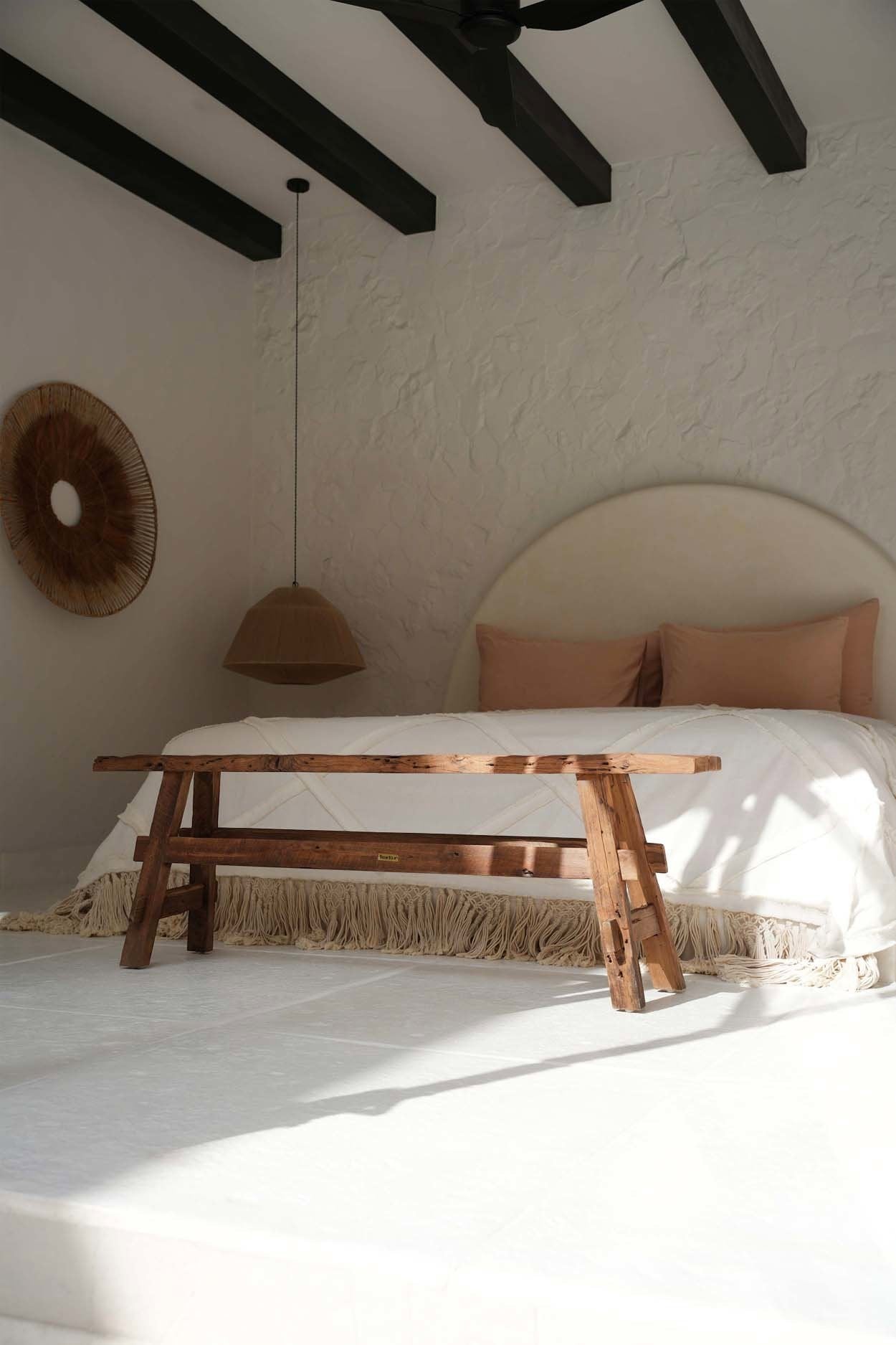 Kayu Living handcrafted solid Indonesian teak rustic bench with natural wood grain finish at the foot of a bed.