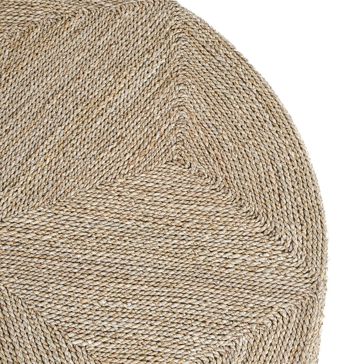 Close-up of a Kayu Living handcrafted natural seagrass pouf featuring a detailed woven geometric pattern.