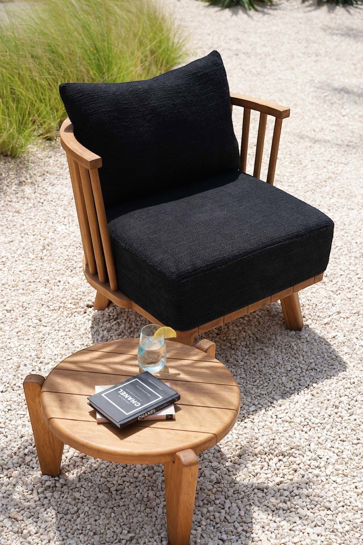 Kayu Living Seseh outdoor coffee table made of reclaimed teak with a round slatted top and three legs.