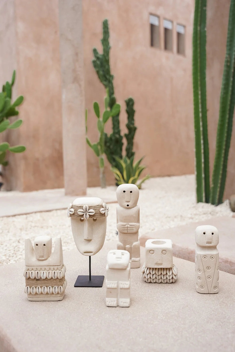 Kayu Living handcrafted stone figurines and white mask on stand, featuring bohemian Balinese artisan decor