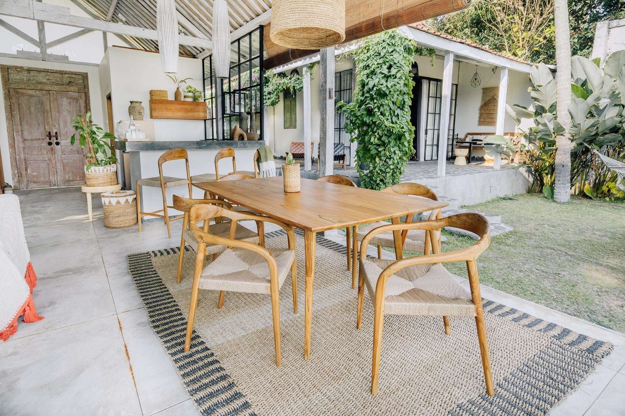 Kayu Living Berawa teak dining table 180x100 cm with woven chairs in natural tones, perfect for outdoor or indoor dining.