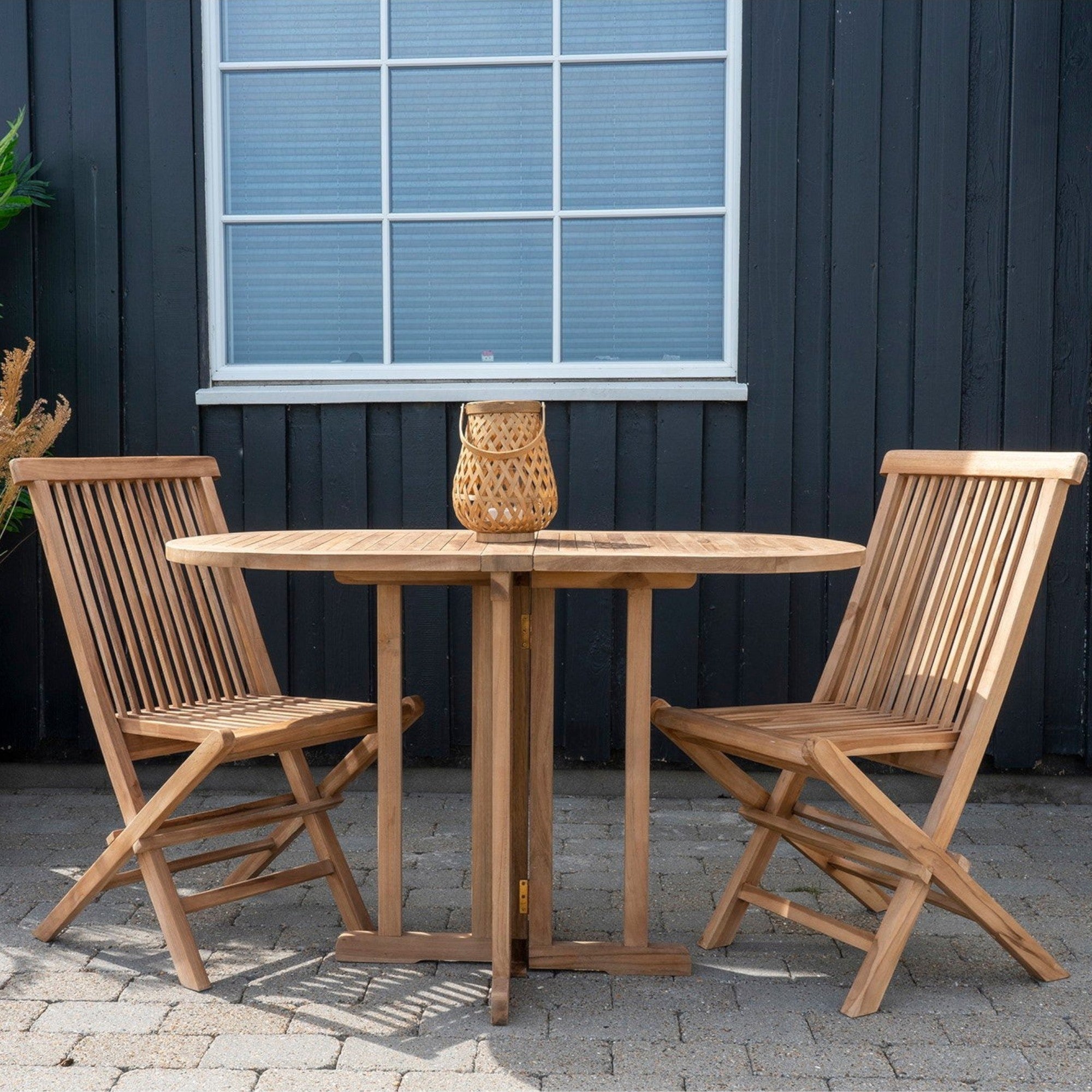 Kayu Living Toledo natural teak wood folding dining chairs set with slatted backrests on a stone patio