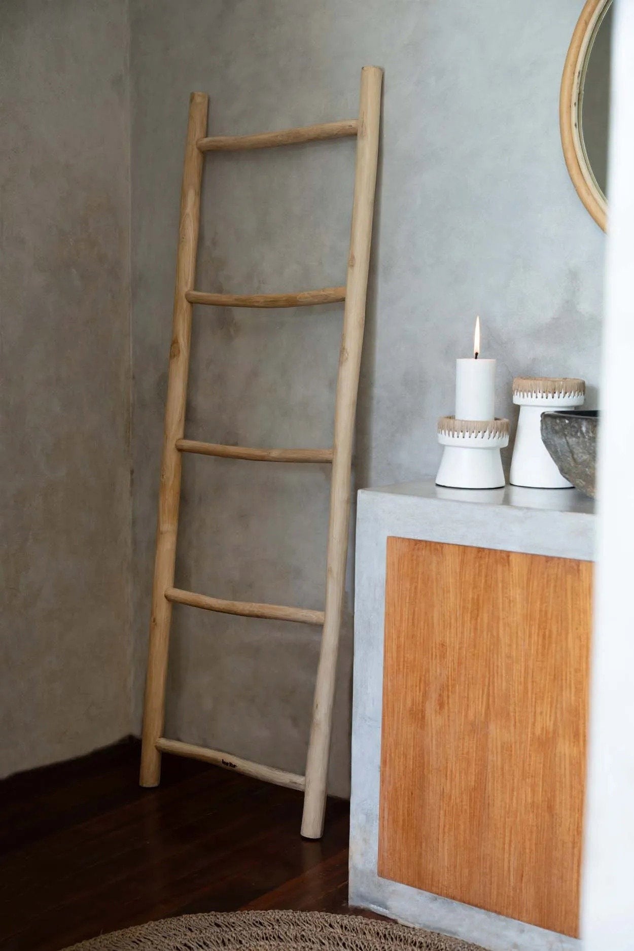 Kayu Living Tulum teak wood decorative ladder leaning against a grey wall for towel or throw storage