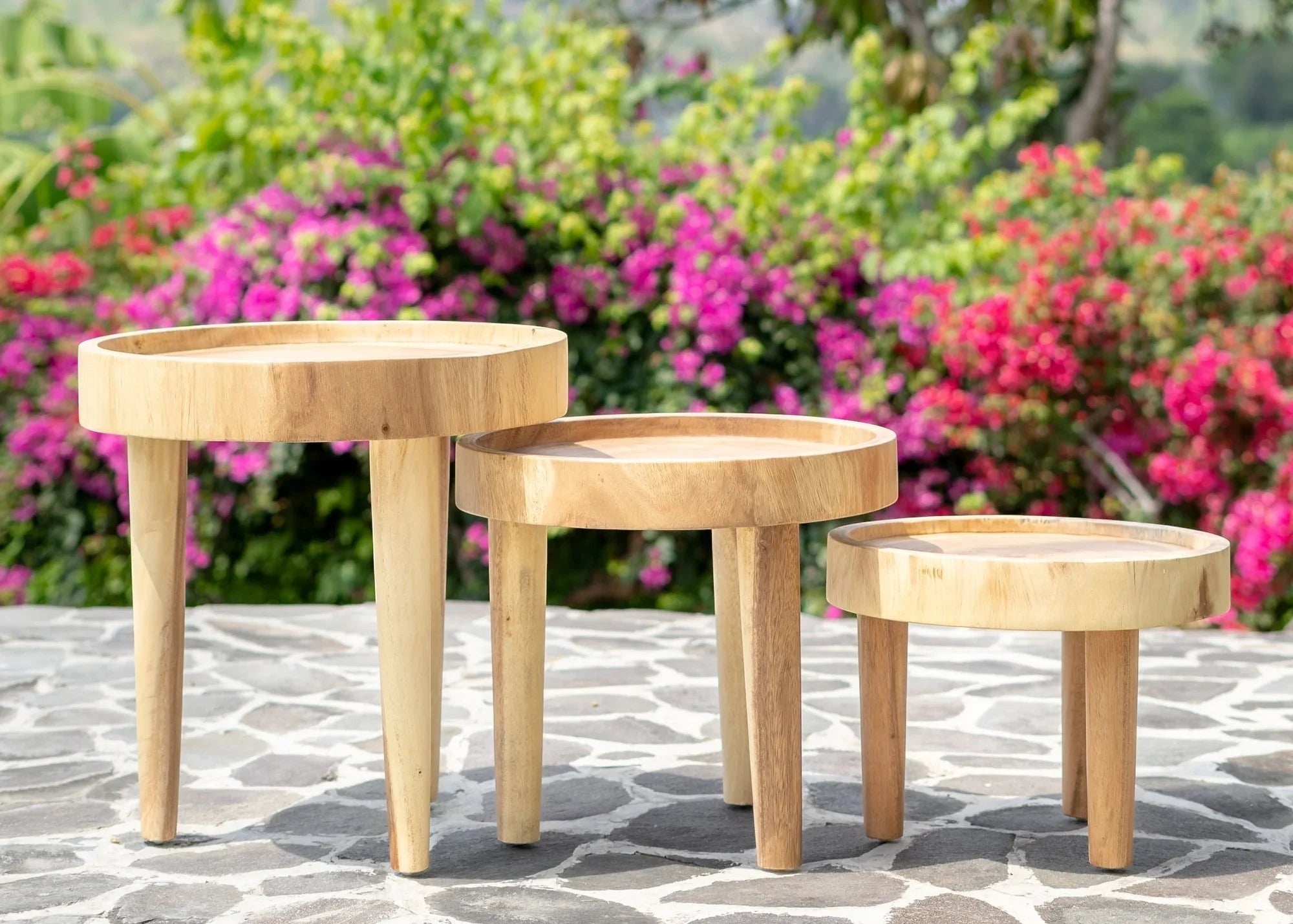 Kayu Living three-legged Ulu side tables in natural suar wood, showcasing unique grain patterns and earthy tones.