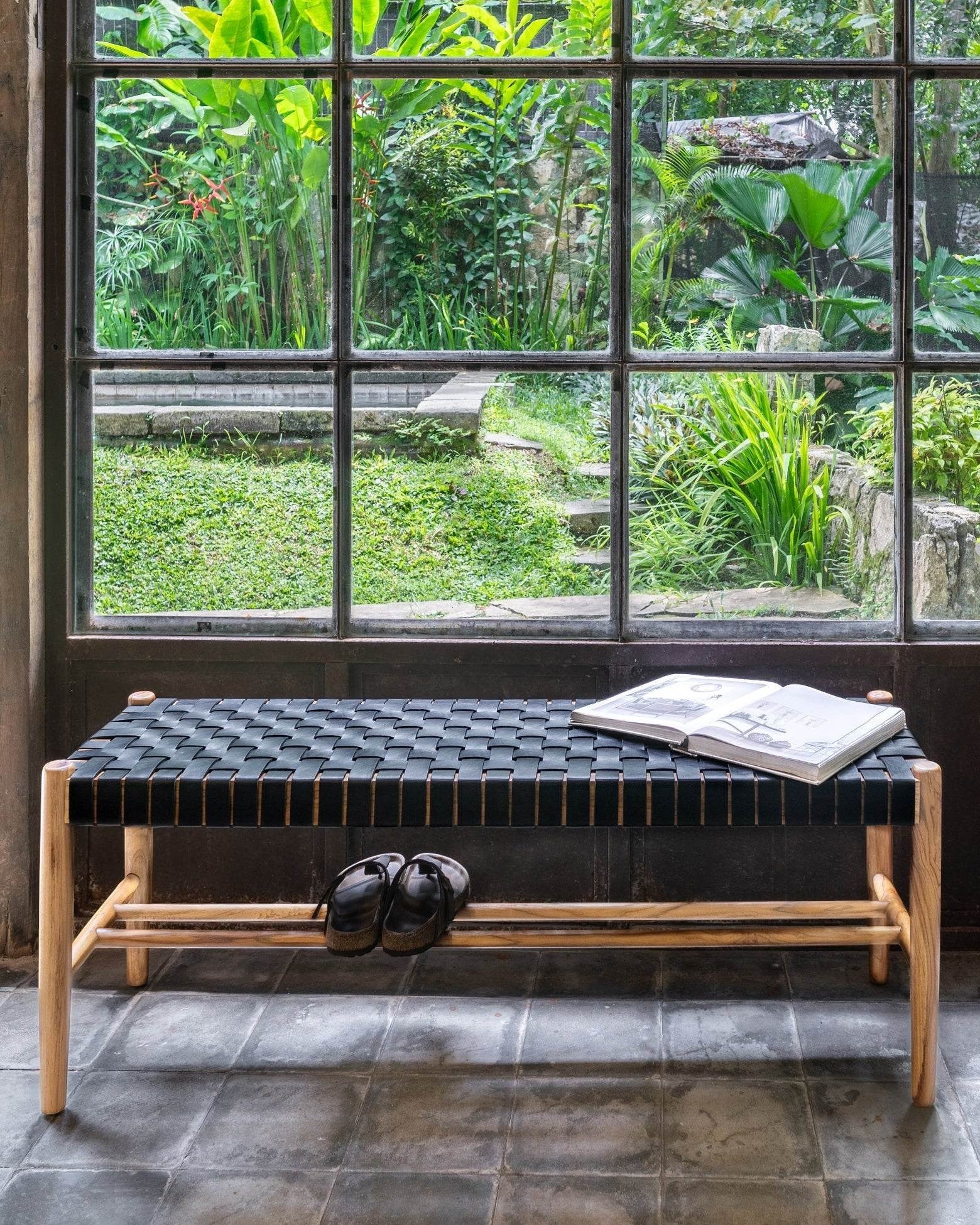 Kayu Living Umalas 120cm bench with solid teak frame and black woven leather seat. Features a lower shelf for shoes.
