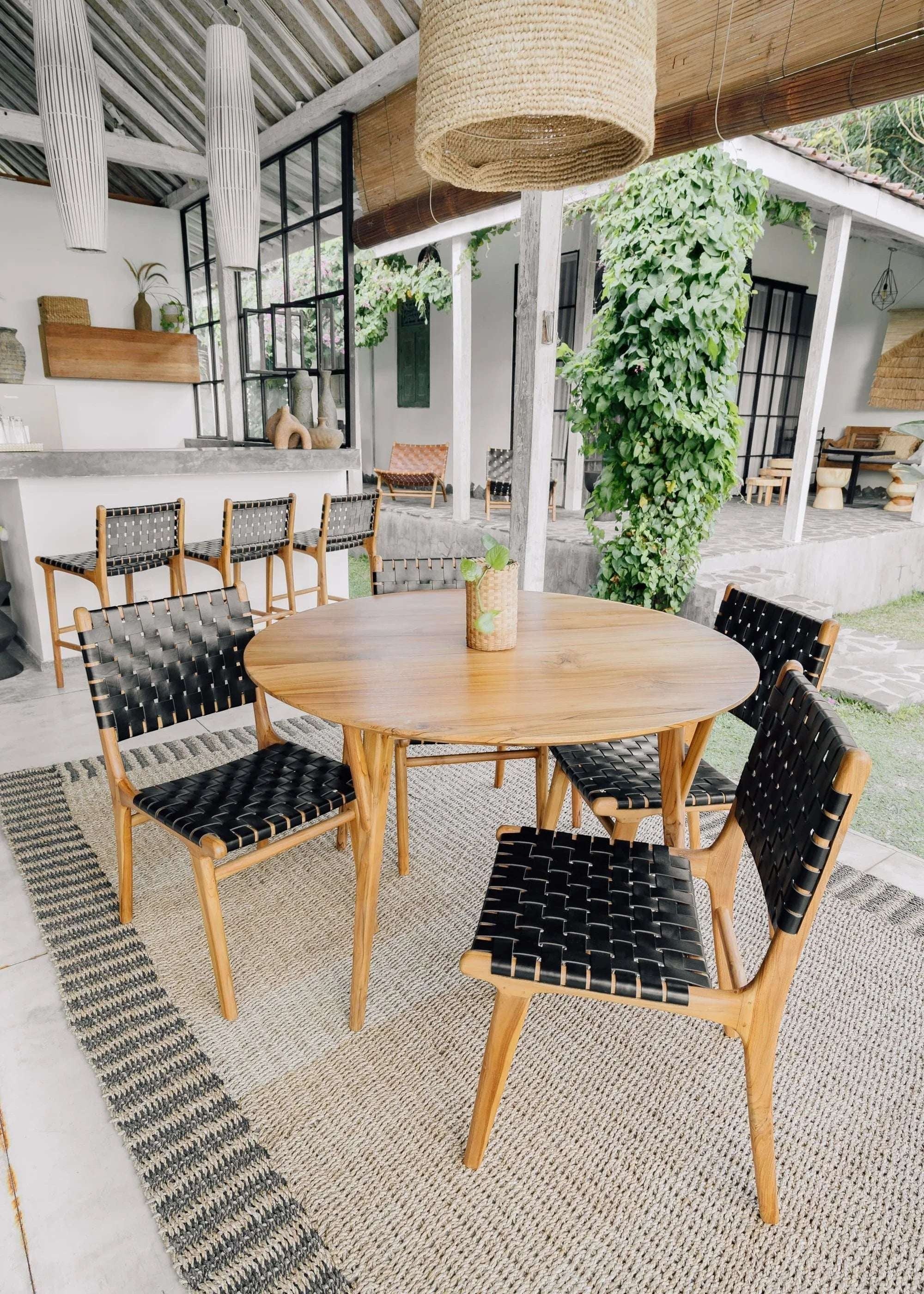 Kayu Living Umalas dining chair with hand-woven black leather seat and teak frame. Modern design, comfortable and durable.