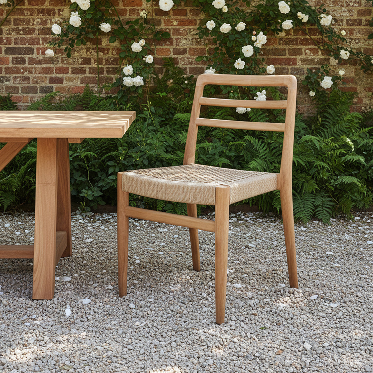 Pair of Verano teak dining chairs with armrests by Raw Materials, showcasing sleek wooden design and comfortable seating.