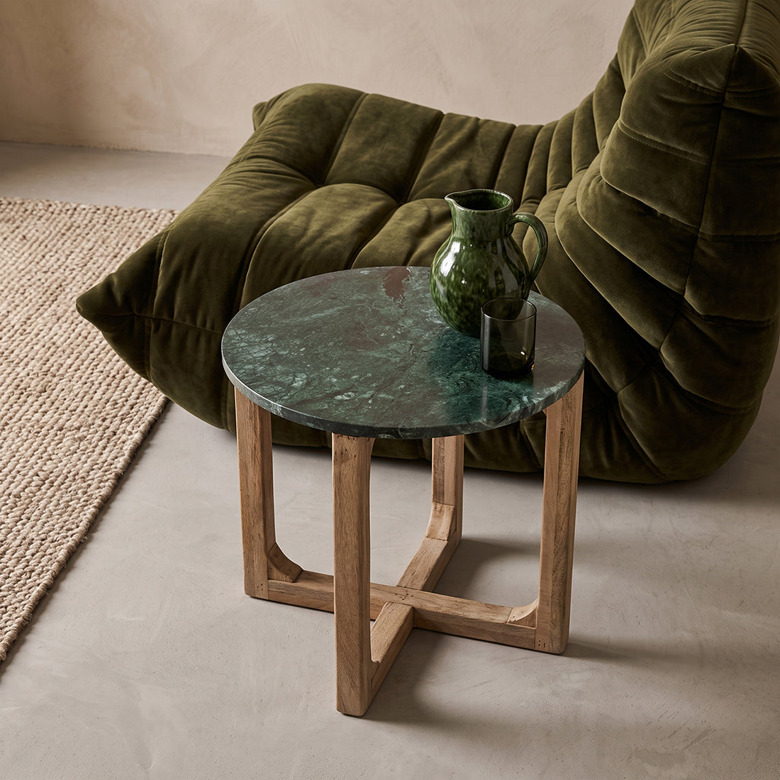 Green marble side table by Raw Materials featuring a sleek, modern design with a round top and cylindrical base.
