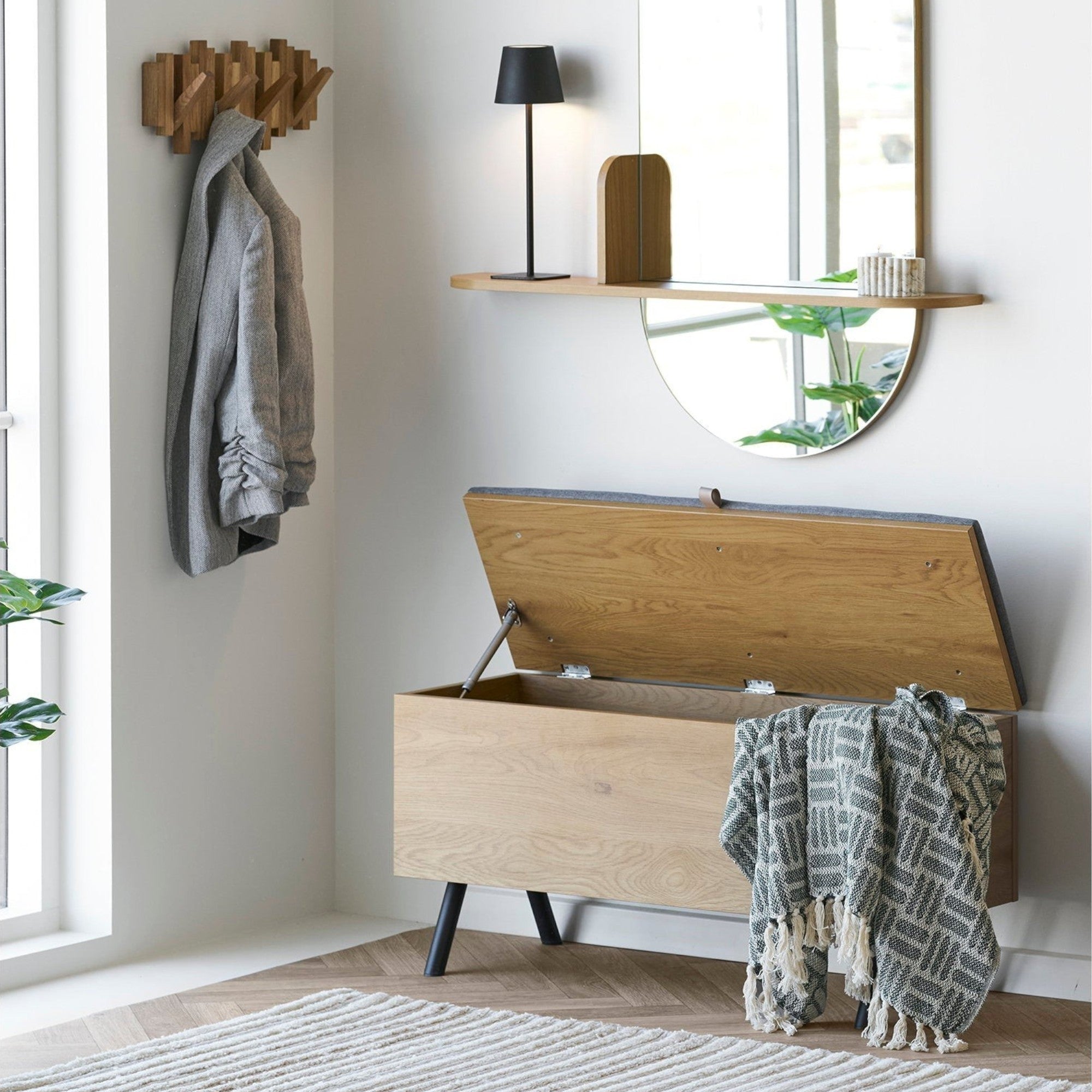 Kayu Living Adana green plaid throw blanket made of recycled cotton draped over a wooden storage bench in an entryway