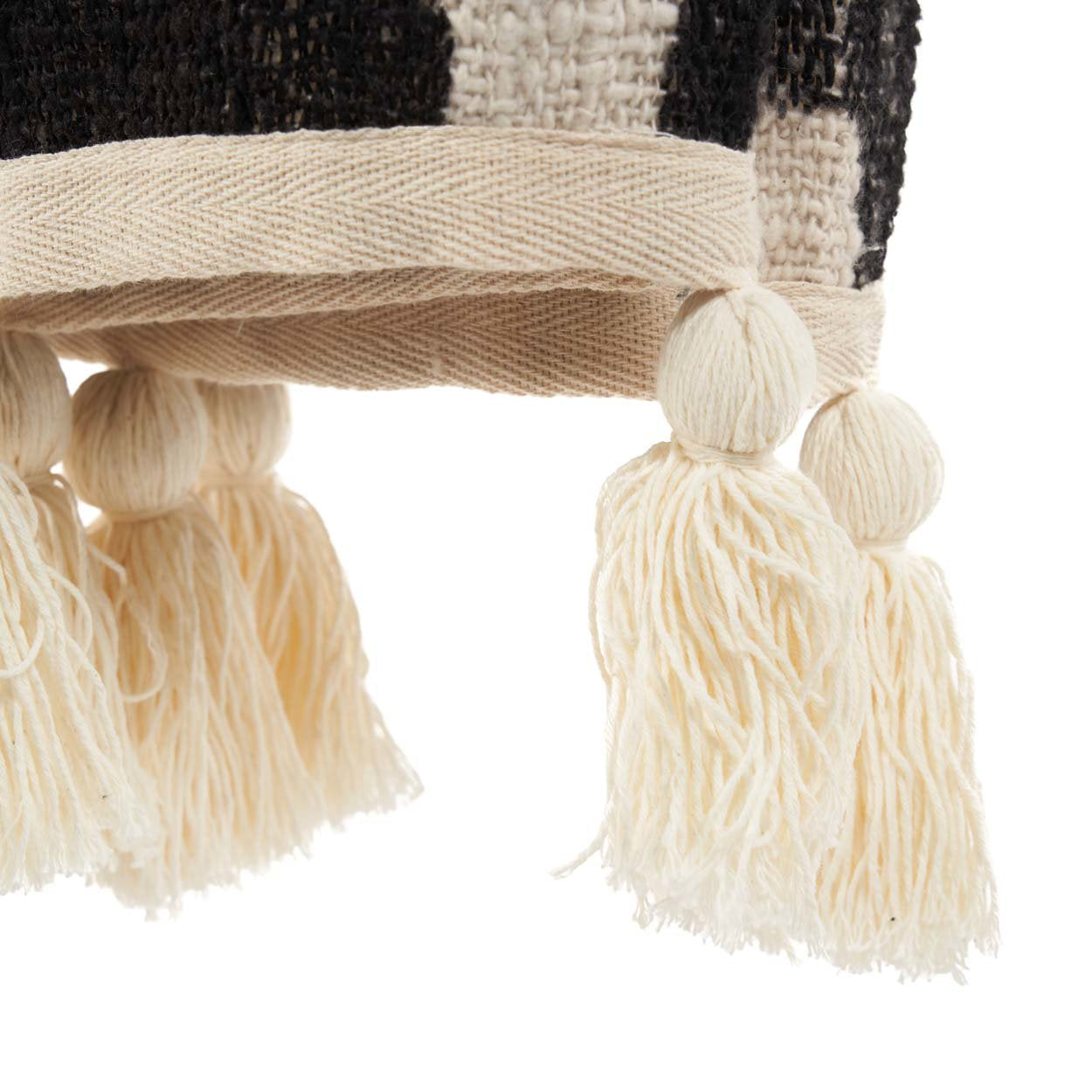Kayu Living Aztec bed throw in natural black cotton featuring detailed woven patterns and decorative cream tassels.