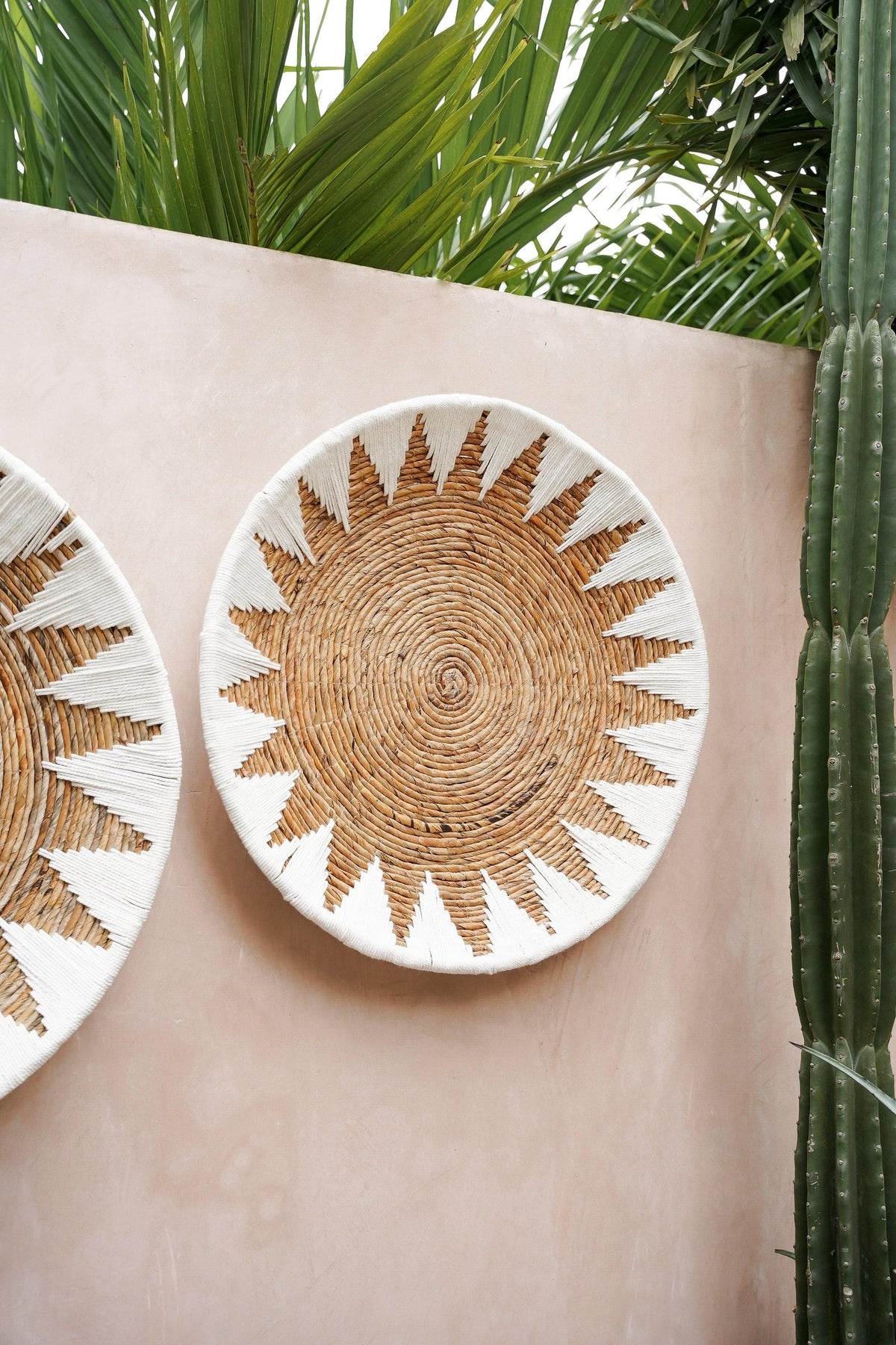 Kayu Living handcrafted bamboo and cotton star plate wall art in brown and white, displayed on a textured wall.