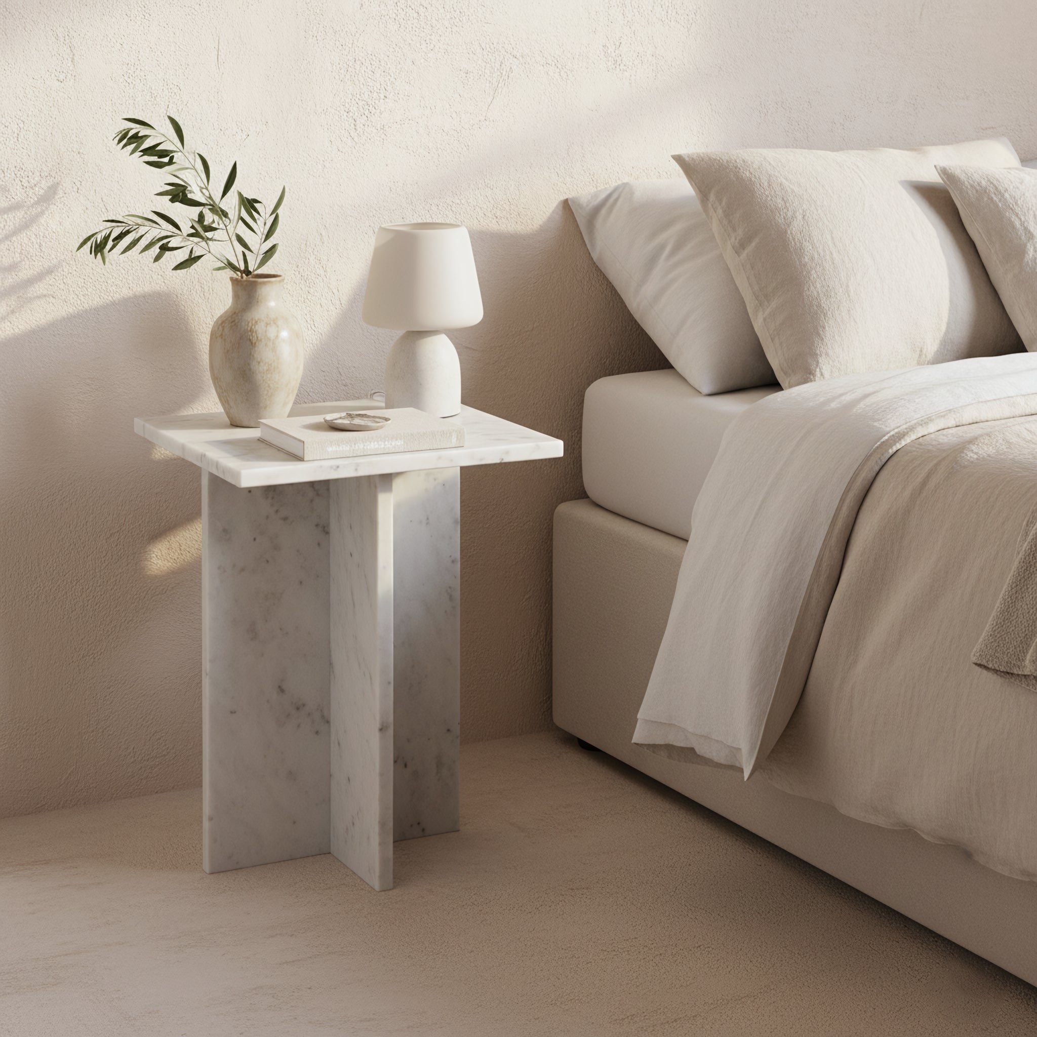Kayu Living Beijing white marble side table with crossed slab base, styled as a bedside table in a neutral bedroom.