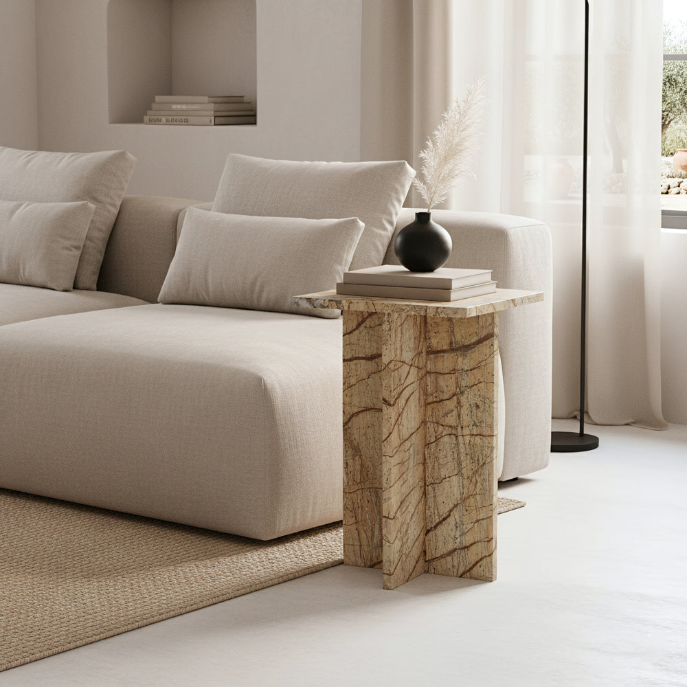 Kayu Living Seoel Bizar square side table in warm-toned marble with unique veining and a cross base next to a sofa.
