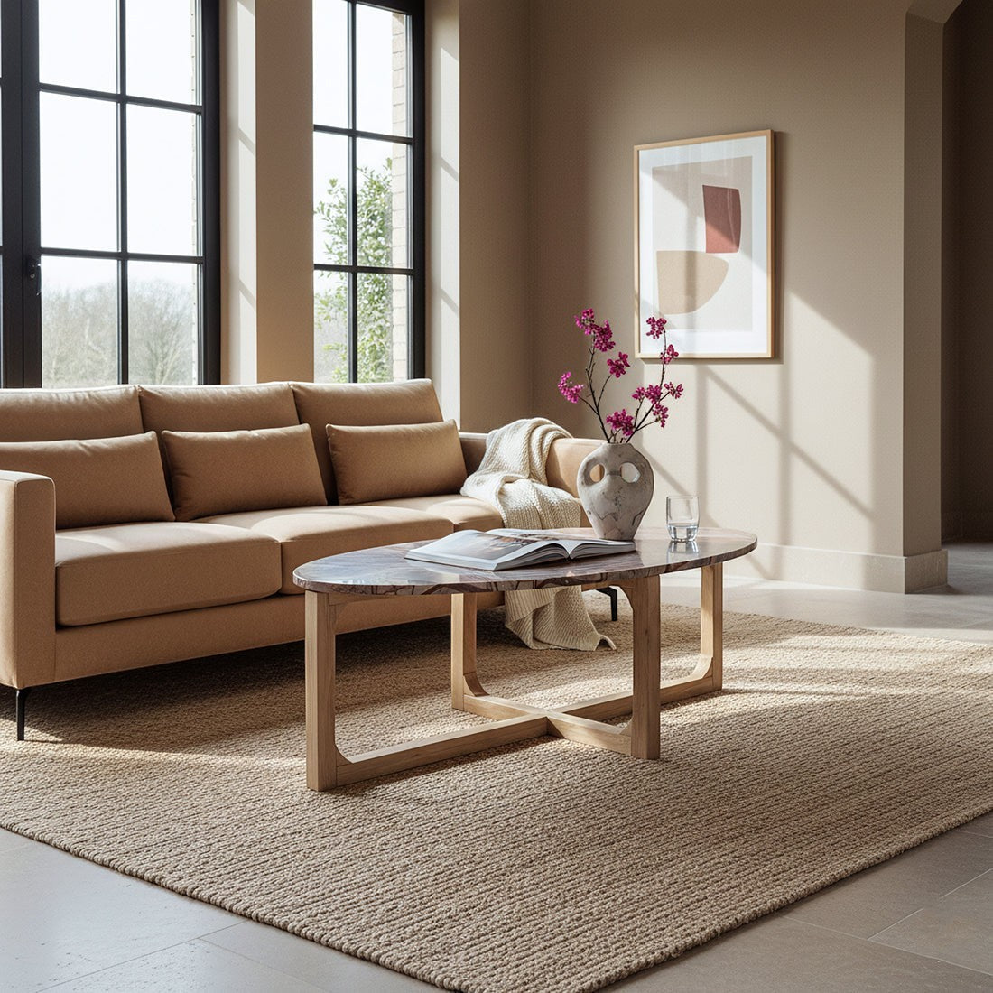 Kayu Living Bizar oval marble coffee table with a veined top and light mango wood cross-frame in a modern living room