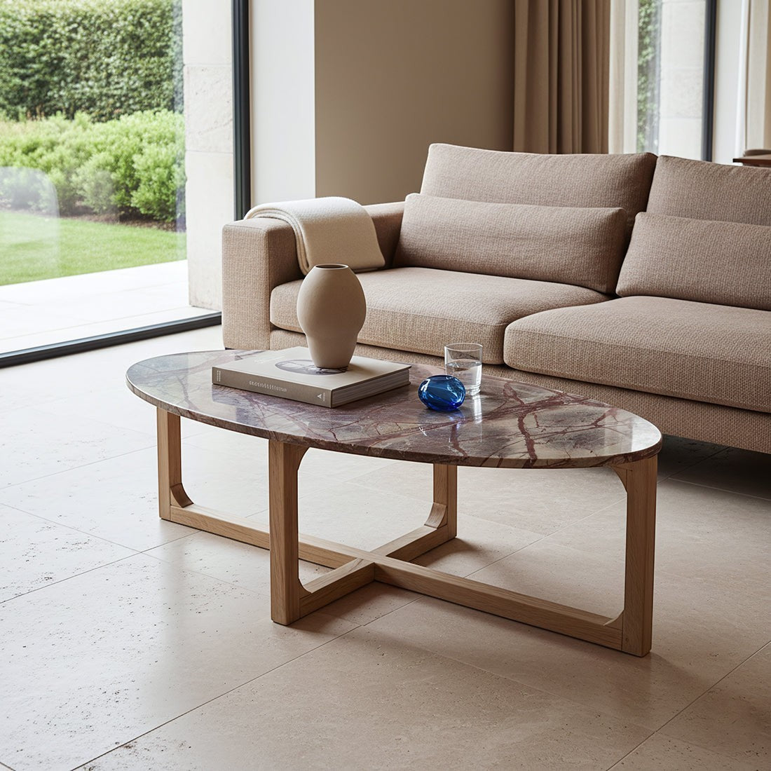 Kayu Living Bizar oval coffee table with a red veined marble top and light mango wood cross-frame in a living room.