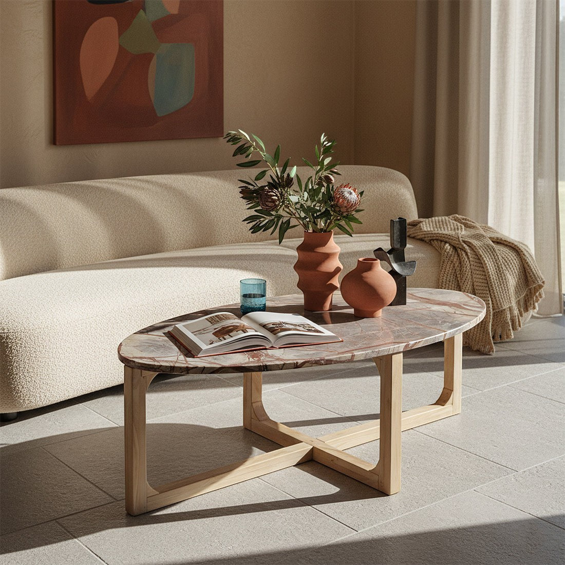 Kayu Living Bizar oval marble coffee table with a light mango wood cross-frame in a sunlit living room setting