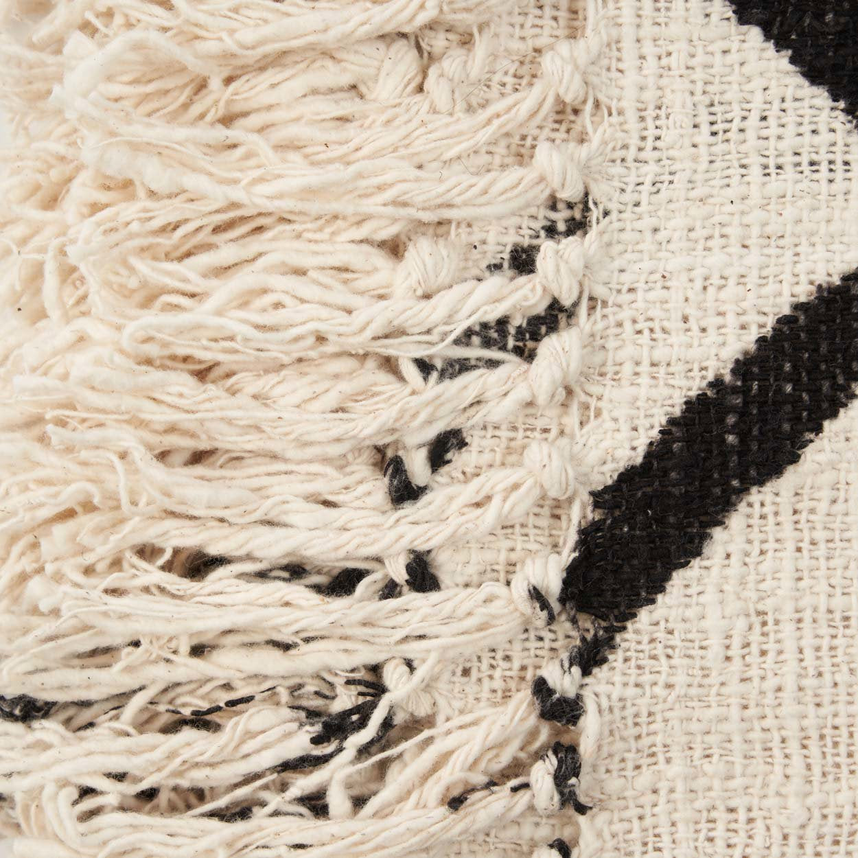 Kayu Living natural black cotton bed throw with detailed fringe texture and evil eye pattern