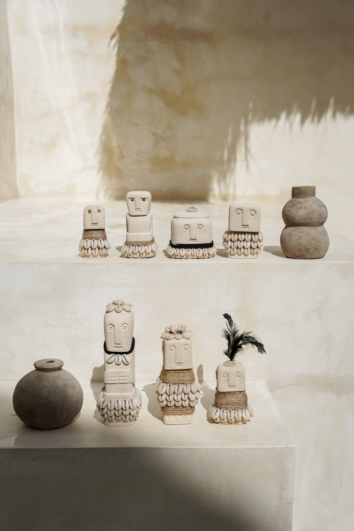 Kayu Living handmade Boho Stone Men figurines featuring natural stone, jute rope, and shell accents on a tiered display