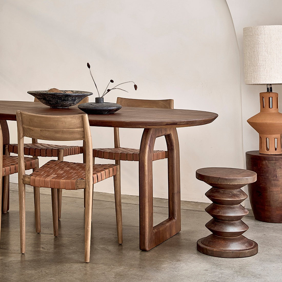 Kayu Living bullnose mango wood dining table with a rounded oval top and open base in a natural wood finish.